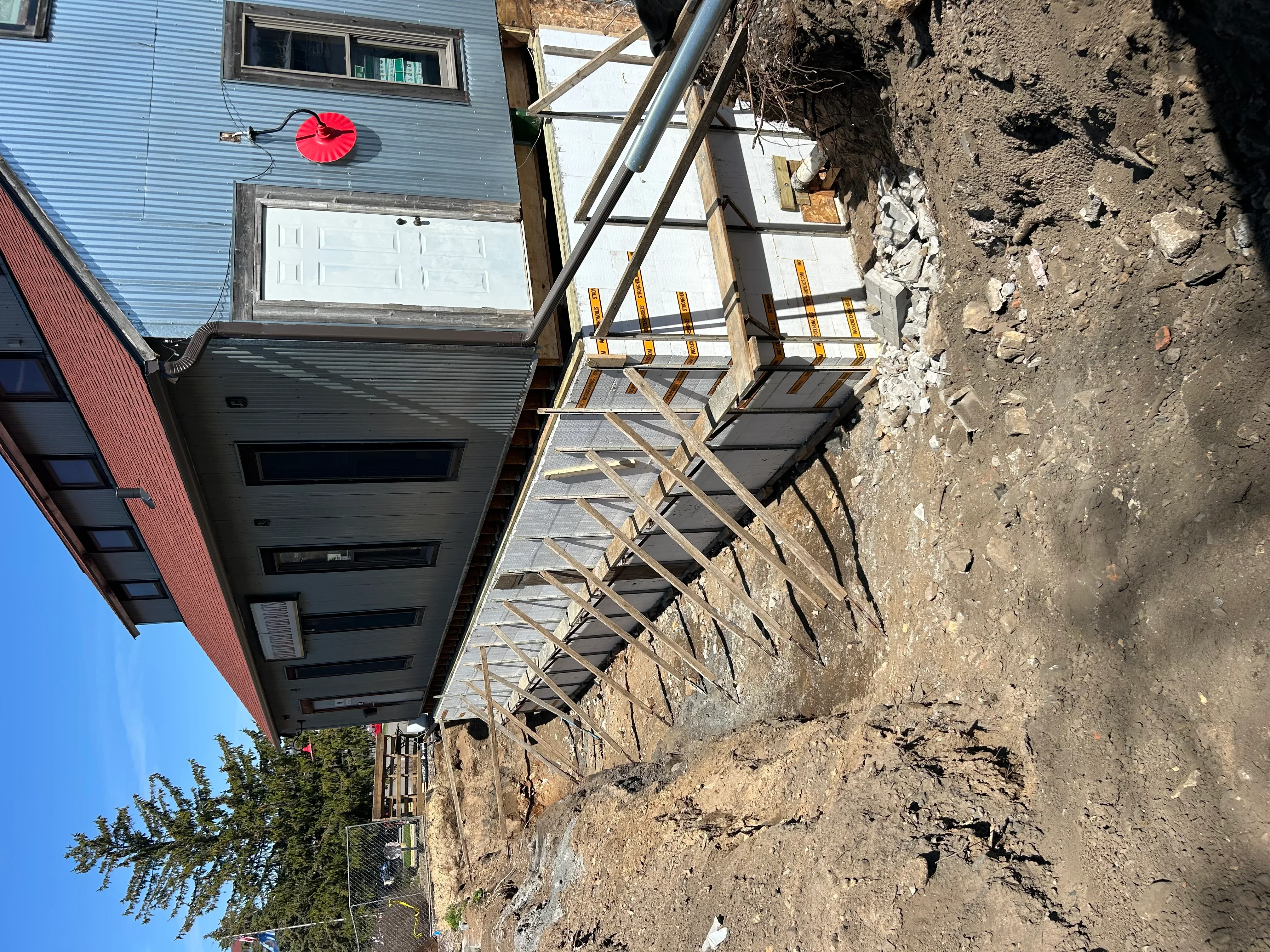 Residential driveway excavation site with graded soil, steel reinforcement, and prepared base
