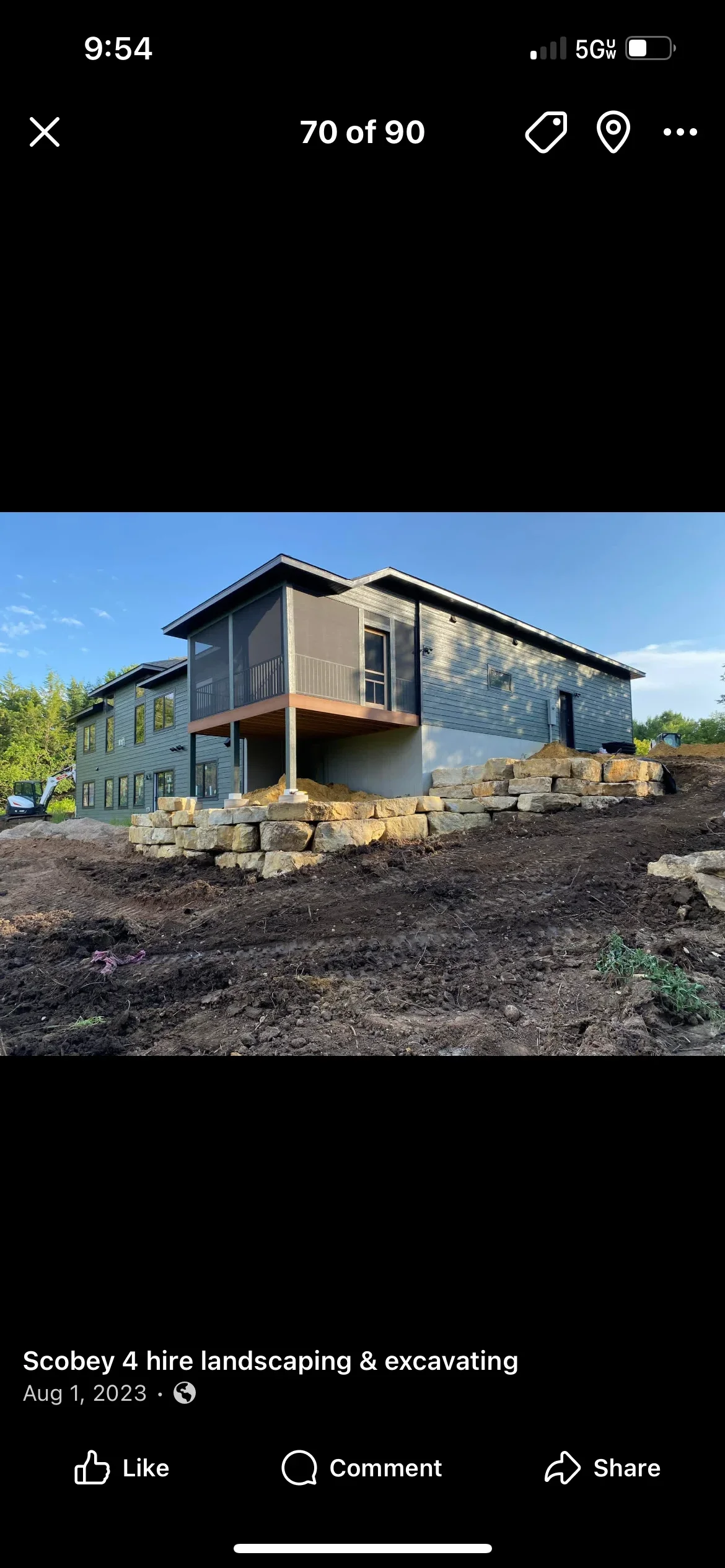 New home construction site with stacked stone retaining wall and cleared excavated lot