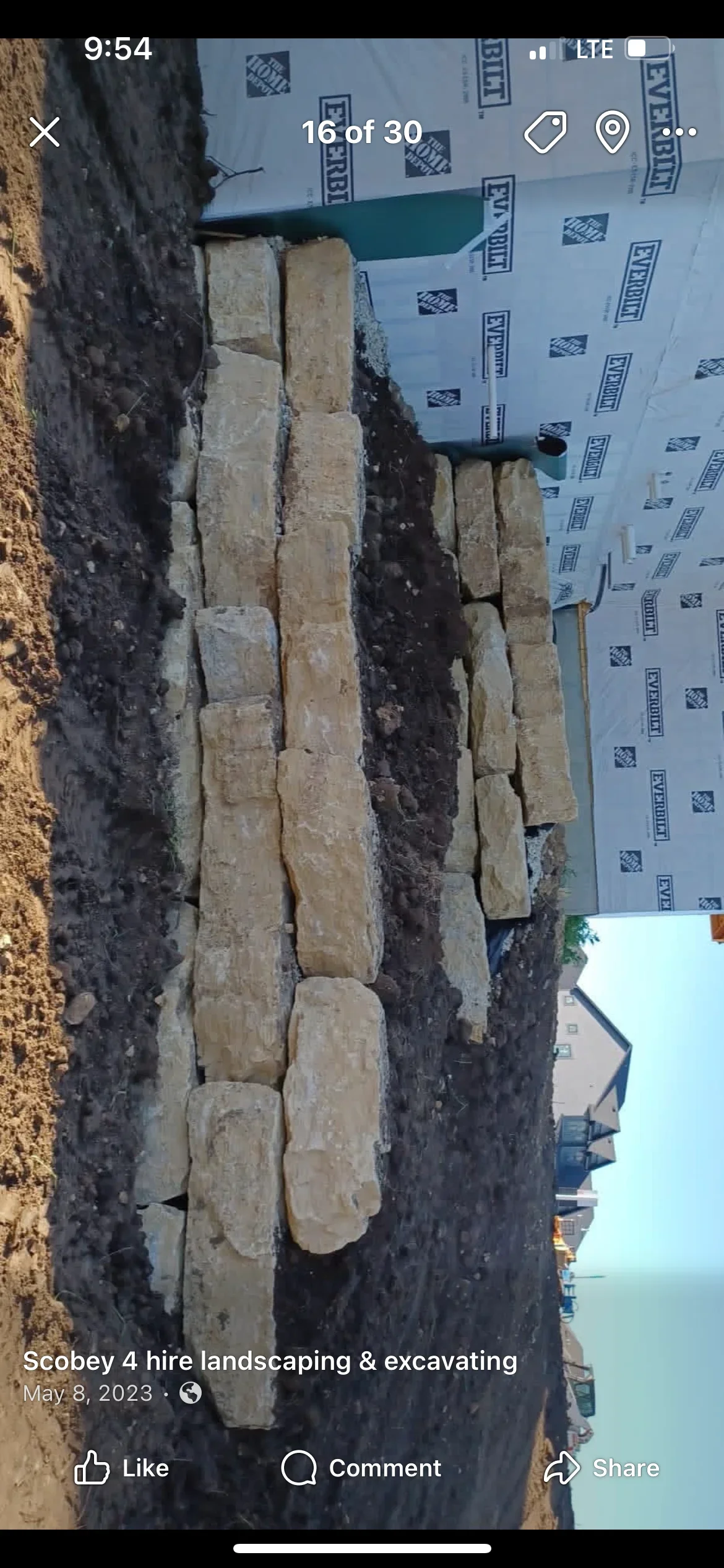 Segmental retaining wall with stacked concrete blocks and drainage membrane